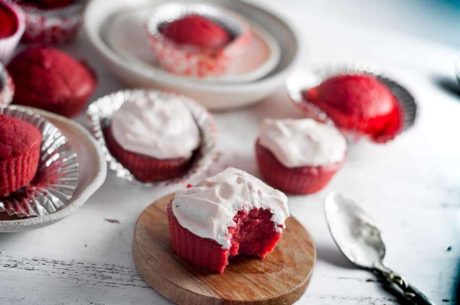 a scattering of red velvet cupcakes on a table